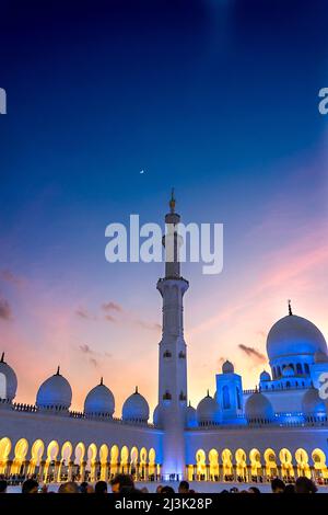 Tramonto con un quarto di luna alla Grande Moschea di Abu Dhabi, Emirati Arabi Uniti, con un minareto di marmo; Abu Dhabi, Emirati Arabi Uniti Foto Stock