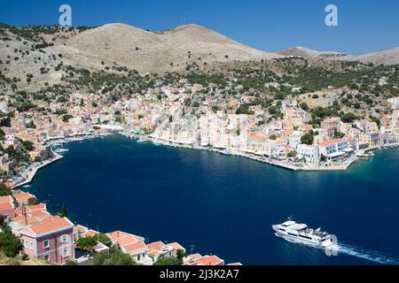 Barche nel porto di Gialos sull'isola di Symi (Simi), gruppo dell'isola del Dodecaneso, Grecia; Gialos, Symi, Dodecaneso, Grecia Foto Stock