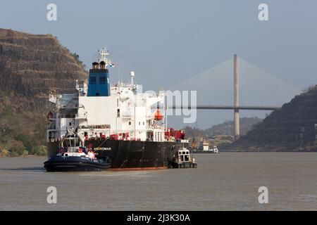 Le barche da rimorchiatore guidano una grande imbarcazione attraverso il canale di Panama vicino a Culebra Cut e al Centennial Bridge; Panama Foto Stock