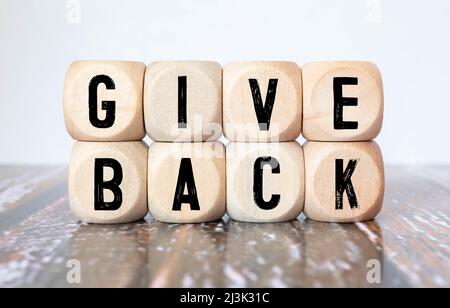 Dia indietro parola scritta sul blocco di legno. Testo di ritorno sulla tabella, concetto Foto Stock