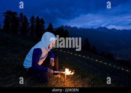 La costruzione e l'illuminazione di un fuoco di cuore sacro sul monte Elferspitze nella valle dello Stubai.; Austria. Foto Stock