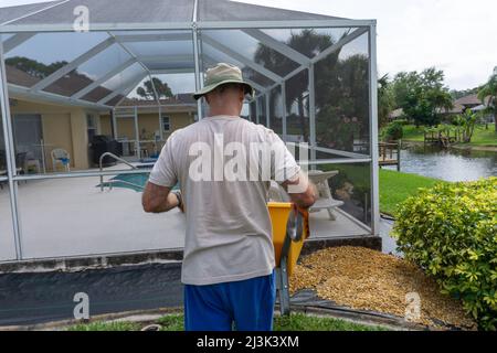 Il giardinaggio in pensione in Florida guida carriola Foto Stock