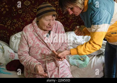 Kiev, Ucraina. 31st Mar 2022. Un volontario visto che dà la medicina quotidiana di Olga. Olga, ora 94 anni, è sopravvissuta al peggio nella seconda guerra mondiale, ora si ritrova nel bel mezzo di un'altra guerra, e si stupisce come 'questa volta, sono i russi che hanno invaso usâ (Credit Image: © Alex Chan Tsz Yuk/SOPA Images via ZUMA Press Wire) Foto Stock