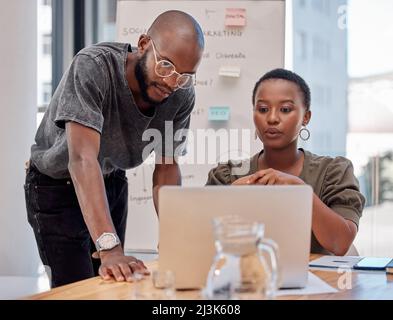 Due teste sono migliori di una. Shot di due giovani uomini d'affari che hanno una discussione in ufficio. Foto Stock