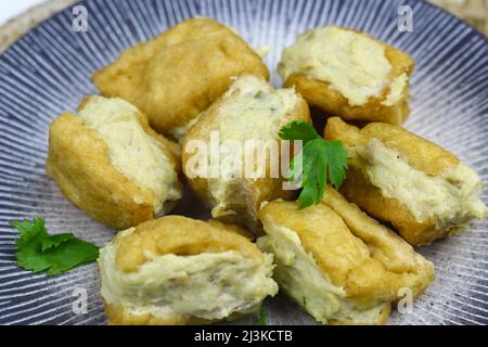 Tahu Bakso, tradizionale spuntino indonesiano a base di tofu, pollo o manzo con farina di tapioce, al vapore e fritto. Servito con salsa al peperoncino. Foto Stock