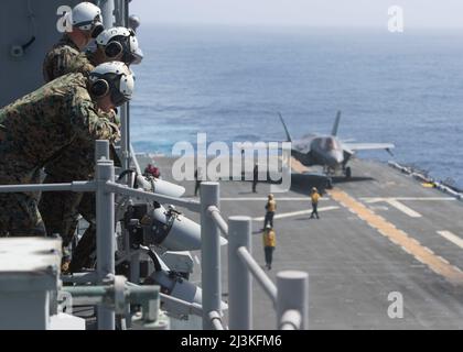 220405-N-VJ326-1014 OCEANO PACIFICO (5 aprile 2022) – i Marines statunitensi attaccati al Marine Fighter Attack Squadron (VMFA) 211 osservano come un F-35B Lightning II si prepara al lancio dal ponte di volo della nave d'assalto anfibio USS Tripoli (LHA 7), aprile 5. VMFA-211 è imbarcato a Tripoli come parte della dimostrazione di concetto Lightning carrier del corpo Marino degli Stati Uniti. La dimostrazione di Lightning Carrier Concept mostra che Tripoli e altre navi d'assalto anfibie sono in grado di operare come piattaforme d'attacco dedicate ad ala fissa quando necessario, in grado di portare la quinta generazione Short Takeoff/Vertical Foto Stock