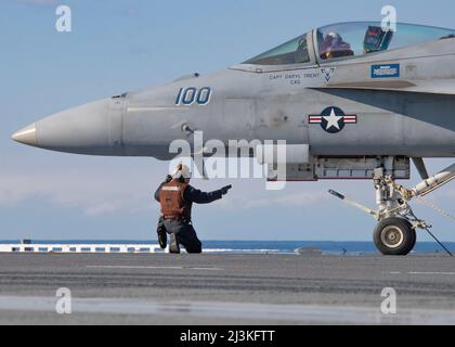 Aviation Electrician's Mate Airman JARRON Darrow, di Nampa, Idaho, assegnato ai 'Ragin' Bulls' di Strike Fighter Squadron (VFA) 37, dirige un F/A-18E Super Hornet, attaccato al VFA 37 sulla piattaforma di volo USS Gerald R. Ford (CVN 78), 28 marzo 2022. Ford è in corso nell'Oceano Atlantico che conduce la certificazione del ponte di volo e la qualificazione del vettore ala dell'aria come parte della fase di base su misura delle navi prima dello spiegamento operativo. (STATI UNITI Foto Navy di Mass Communication Specialist 2nd Classe Nolan Pennington) Foto Stock