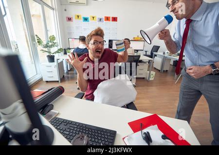 Maschio caucasico che è mobbed dal suo capo in ufficio Foto Stock