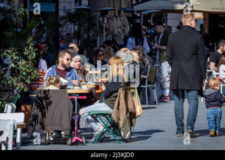 Foto di una terrazza piena nel centro della città di Belgrado, Serbia, persone seduti in un caffè, con un focus su una famiglia. Foto Stock