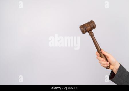 Donna che tiene il gavel del giudice su sfondo bianco. Foto Stock