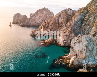 Vista aerea di pedalò lungo la costa rocciosa sul Capo Est di Cabo al tramonto; Cabo San Lucas, Baja California sur, Messico Foto Stock