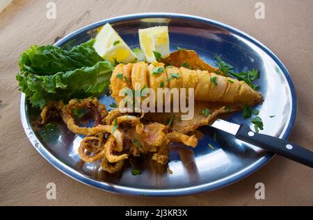 Cena Calimari servita con garnishes di lattuga e limone, ristorante nel porto di Kastellorizo Foto Stock
