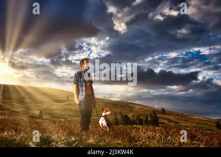 Escursionisti con un cane alla luce del sole sul Feldberg nella Foresta Nera Foto Stock