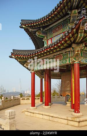 Un tradizionale campanile pavilion al tempio Jiuhuashan con la città moderna in background, vicino Lago Xuanwu, Nanjing, provincia dello Jiangsu, Cina. Foto Stock