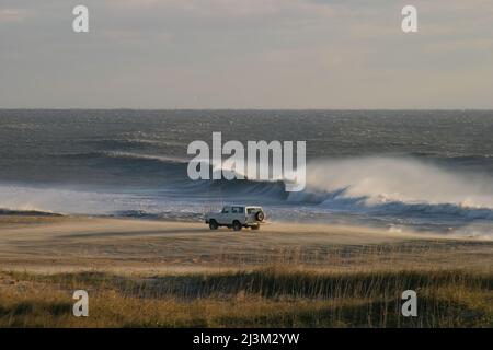 Vento, onde e pescatore in un SUV su una spiaggia in Outer Banks.; Outer Banks, North Carolina. Foto Stock