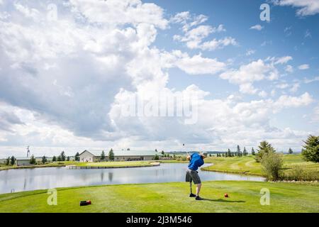 Amputee con protesi di gamba che guida la palla sul campo da golf; Okotoks, Alberta, Canada Foto Stock
