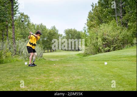 Amputee con protesi delle gambe che si swing sul campo da golf; Okotoks, Alberta, Canada Foto Stock