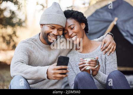 Bene ricordisi di questo per sempre. Scatto di una giovane coppia che prende un selfie durante il campeggio. Foto Stock