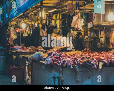 Macellaio che lavora a tarda notte alla bancarella del mercato, Taitung Foto Stock