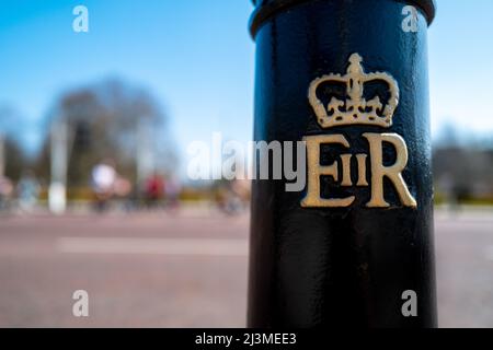 Londra, Regno Unito - 26 marzo 2022: Il bolard con la regina Elisabetta 2nd insignia fuori da Buckingham Palace, Londra. Hyde Park può essere visto dietro su un luminoso s Foto Stock