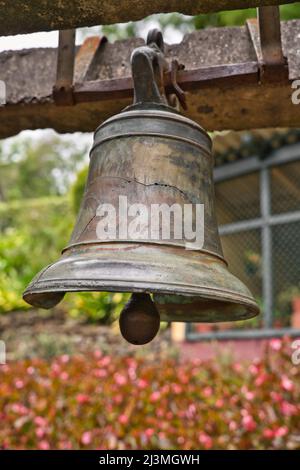 Una vecchia campana rotta è appesa nel giardino botanico di Funchal, Madeira, Portogallo Foto Stock