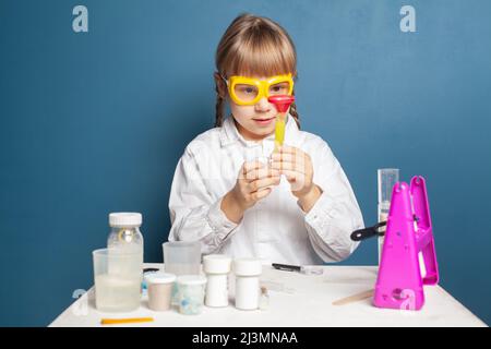 Studente bambino intelligente che si diverte mentre fa esperimenti scientifici Foto Stock