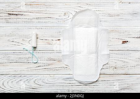 tamponi e tampone donna - tamponi sanitari si trovano accanto a un tampone su uno sfondo isolato su sfondo rosa e viola. Igiene femminile e mestruale p Foto Stock