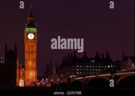 Big ben of the Houses of Parliament Londra Inghilterra Regno Unito di notte che colpisce la mezzanotte di Capodanno su Westminster Bridge, una popolare terra cittadina Foto Stock