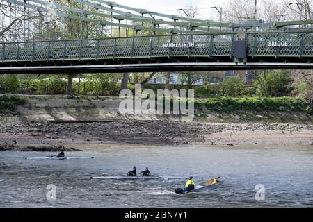 I vogatori passano sotto il chiuso Hammersmith Bridge mentre si allenano sul Tamigi, passando per le proprietà lungo il fiume vicino Barnes, il 6th aprile 2022, a Londra, Inghilterra. I controlli di sicurezza hanno rivelato "errori critici" e Hammersmith e Fulham Council hanno detto che è stato lasciato senza scelta se non chiudere il ponte di 132 anni prima che i costi di ristrutturazione possano essere soddisfatti. Nel marzo 2022, è stata approvata una nuova spesa in conto capitale di £ 3,5million per progredire nella progettazione di concept e nei lavori associati per stabilizzare la struttura di grado II. Foto Stock