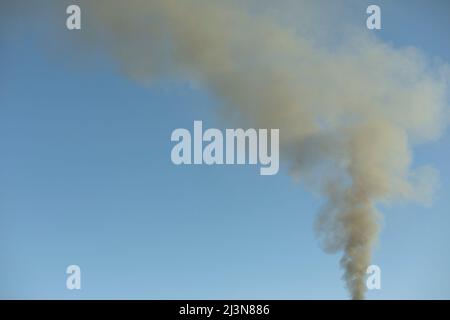 Fumo da camino. Fumo nel cielo. Riscaldamento domestico. Tubo sul tetto di casa. Foto Stock