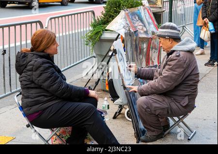 New York City, New York, USA - 21 novembre 2021: Un artista che beve un ritratto di una donna seduto su una sedia su un marciapiede fuori dal parco centrale Foto Stock