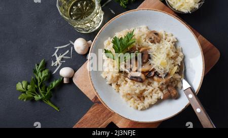 Risotto ai funghi guarnito con prezzemolo e parmigiano. Foto Stock