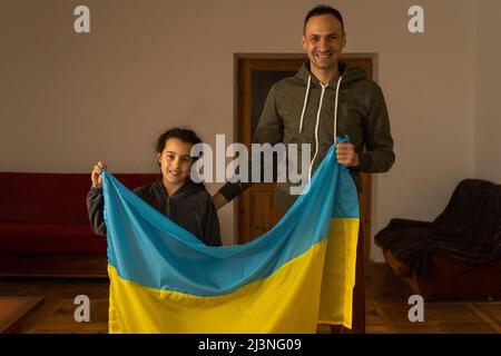 Famiglia con un bambino che guarda la macchina fotografica e bandiera Ucraina Foto Stock