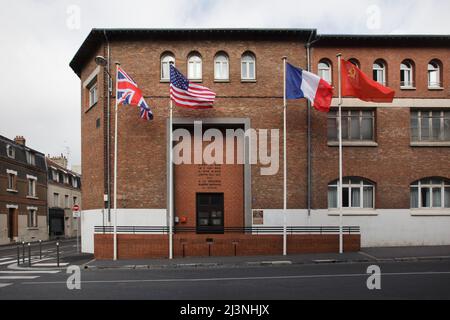 Bandiere nazionali del Regno Unito, degli Stati Uniti d'America, della Francia e dell'Unione Sovietica ondano all'ingresso del Museo della resa (Musée de la Reddition) a Reims, Francia. Il primo strumento tedesco di resa che ha posto fine alla seconda guerra mondiale in Europa è stato firmato in questo edificio alle 02:41 ora dell'Europa centrale (CET) il 7 maggio 1945. Foto Stock