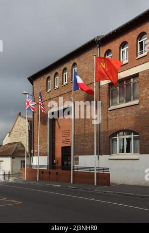 Bandiere nazionali del Regno Unito, degli Stati Uniti d'America, della Francia e dell'Unione Sovietica ondano all'ingresso del Museo della resa (Musée de la Reddition) a Reims, Francia. Il primo strumento tedesco di resa che ha posto fine alla seconda guerra mondiale in Europa è stato firmato in questo edificio alle 02:41 ora dell'Europa centrale (CET) il 7 maggio 1945. Foto Stock