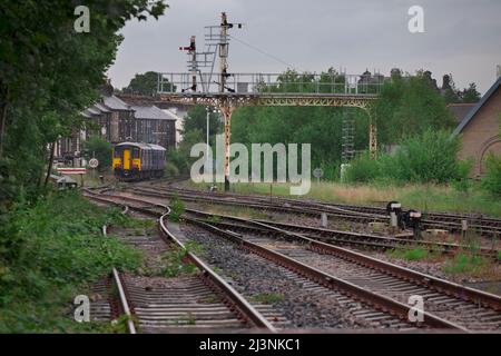 Northern Rail classe 150 unità multipla diesel train150224 che passa attraverso un gantry di segnale semaforo in partenza da Harrogate Foto Stock