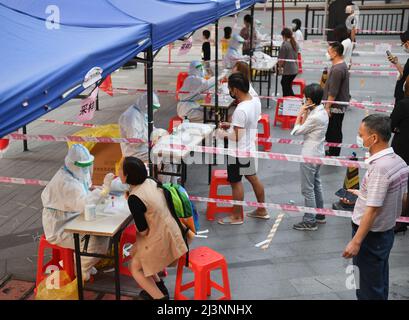 Guangzhou, la provincia cinese di Guangdong. 9th Apr 2022. Gli operatori sanitari prelevano campioni di tampone dai residenti per il test degli acidi nucleici in una comunità nel distretto di Liwan di Guangzhou, provincia cinese meridionale di Guangdong, 9 aprile 2022. Guangzhou ha condotto test in tutta la città sugli acidi nucleici da venerdì a sabato. Credit: Deng Hua/Xinhua/Alamy Live News Foto Stock