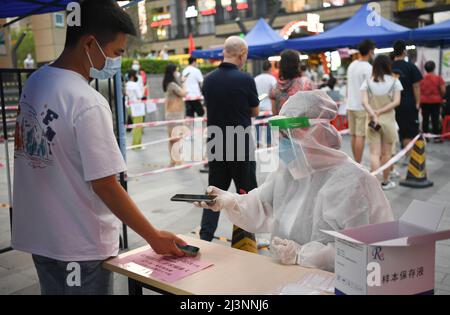 Guangzhou, la provincia cinese di Guangdong. 9th Apr 2022. Un operatore medico scansiona le informazioni di un residente per il test degli acidi nucleici in una comunità nel distretto di Liwan di Guangzhou, provincia cinese meridionale di Guangdong, 9 aprile 2022. Guangzhou ha condotto test in tutta la città sugli acidi nucleici da venerdì a sabato. Credit: Deng Hua/Xinhua/Alamy Live News Foto Stock