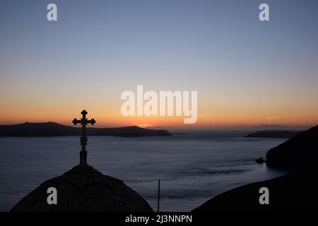 Vista di una chiesa ortodossa religiosa e una croce sulla cima, mentre il sole tramonta in modo spettacolare Foto Stock