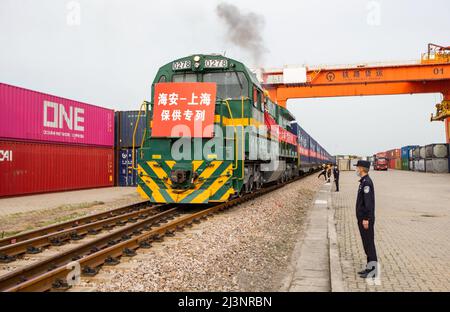 NANTONG, CINA - 9 APRILE 2022 - il primo treno di rifornimento garantito 'Hai 'an - Shanghai', caricato con 38 automobili e 76 teu di riso, farina, olio commestibile, e. Foto Stock