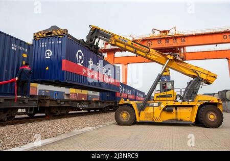 NANTONG, CINA - 9 APRILE 2022 - il primo treno di rifornimento garantito 'Hai 'an - Shanghai', caricato con 38 automobili e 76 teu di riso, farina, olio commestibile, e. Foto Stock