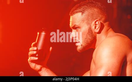 Un uomo muscoloso bevande una bottiglia di acqua dopo un sudato, duro  allenamento e regime di esercizio Foto stock - Alamy