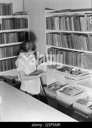 Campo di Arvin per lavoratori migranti (Farm Security Administration-FSA) California. Una piccola biblioteca in campo con Works Progress Administration (WPA) bibliotecario in carica è ora a disposizione dei lavoratori agricoli. Parte del programma di ricreazione e di educazione istituito in tutti i campi governativi per le famiglie migratorie. Foto Stock