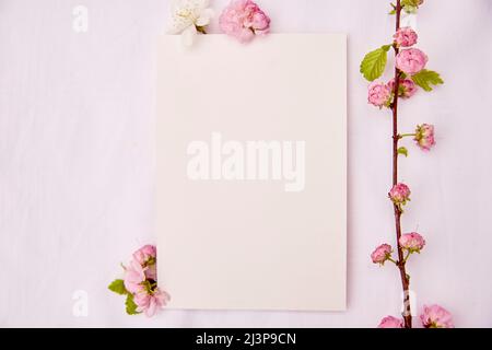 Romantico mockup femminile verticale di carta da cancelleria con fiori primaverili bianchi e rosa. Matrimonio, compleanno, invito, giorno della madre mock up scheda conc Foto Stock