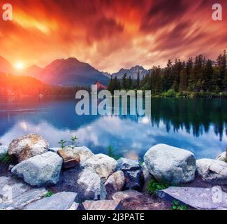 Splendida vista sul lago sotto il cielo rosso. Scena drammatica insolita. Località famosa località Parco Nazionale High Tatra, Strbske pleso, Slovacchia, Europa. Arti Foto Stock