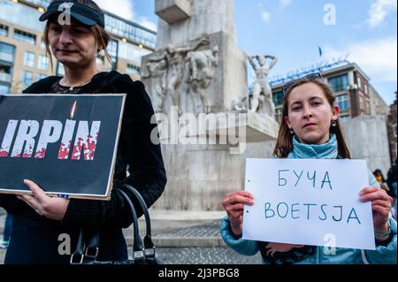 Una donna tiene un cartello in onore delle vittime della città di Bucha. Dopo i terribili eventi accaduti a Bucha (Ucraina) questa settimana, la comunità russa nei Paesi Bassi ha organizzato una veglia di dolore per commemorare le vittime delle atrocità della Federazione russa. La gente si radunò in piazza Dam indossando abiti neri e cartelli con i nomi delle città ucraine attaccate dall'esercito russo. L'evento è stato un'azione di lutto silenzioso senza annunci o discorsi. (Foto di Ana Fernandez/SOPA Images/Sipa USA) Foto Stock