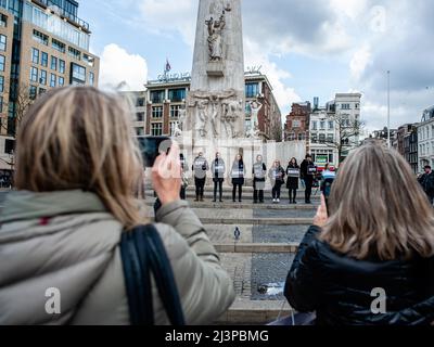 La gente è vista scattare foto della gente che tiene i cartelli. Dopo i terribili eventi accaduti a Bucha (Ucraina) questa settimana, la comunità russa nei Paesi Bassi ha organizzato una veglia di dolore per commemorare le vittime delle atrocità della Federazione russa. La gente si radunò in piazza Dam indossando abiti neri e cartelli con i nomi delle città ucraine attaccate dall'esercito russo. L'evento è stato un'azione di lutto silenzioso senza annunci o discorsi. (Foto di Ana Fernandez/SOPA Images/Sipa USA) Foto Stock