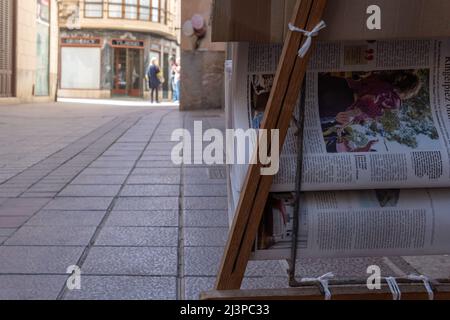 Felanitx, Spagna; aprile 07 2022: Primo piano dei giornali esposti su una strada nella città di Mallorcan di Felanitx, con pedoni sullo sfondo Foto Stock