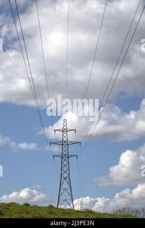 Produzione e distribuzione di energia, turbine eoliche rinnovabili, linee aeree e piloni per la trasmissione e la distribuzione di energia Foto Stock