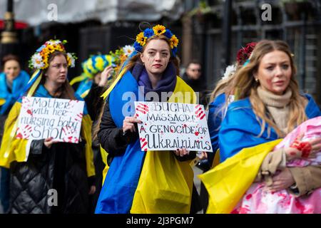 Londra, Regno Unito. 9 aprile 2022. Le donne che indossano la tradizionale headwear floreale portano segni in risposta alle attività nella città di Buca in Ucraina, mentre camminano verso una protesta di solidarietà Ucraina fuori Downing Street. L’invasione dell’Ucraina da parte della Russia è iniziata il 24 febbraio 2022 e non mostra alcun segno di fine. Credit: Stephen Chung / Alamy Live News Foto Stock